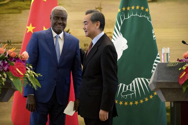 Image result for Chairman of the AU Commission Moussa Faki Mahamat, left, and Chinese Foreign Minister Wang Yi shake hands at the end of a joint press conference in Beijing, China (Feb. 8, 2018).